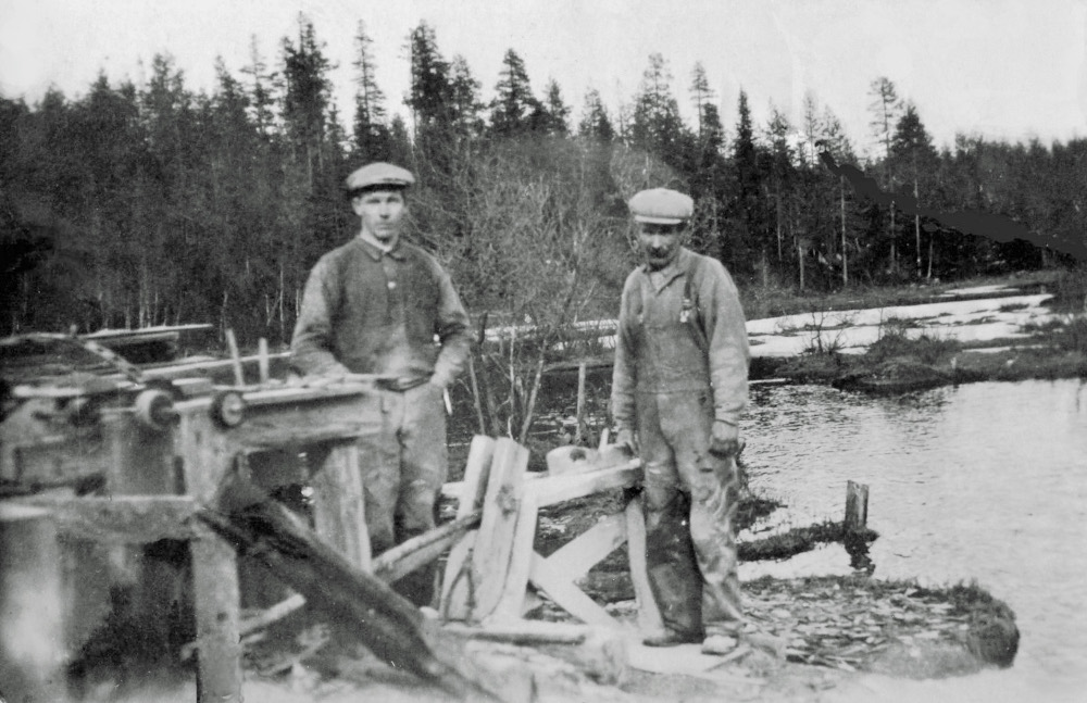 Äldre bild av två personer som står bredvid en brynhyvel
